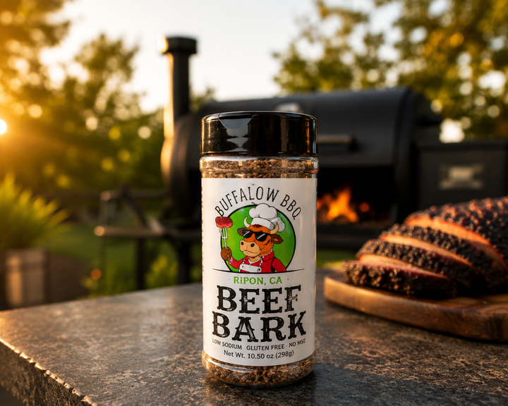 BuffalowBBQ Beef Bark seasoning bottle displayed in front of a smoker with sliced smoked brisket on a wooden cutting board.
